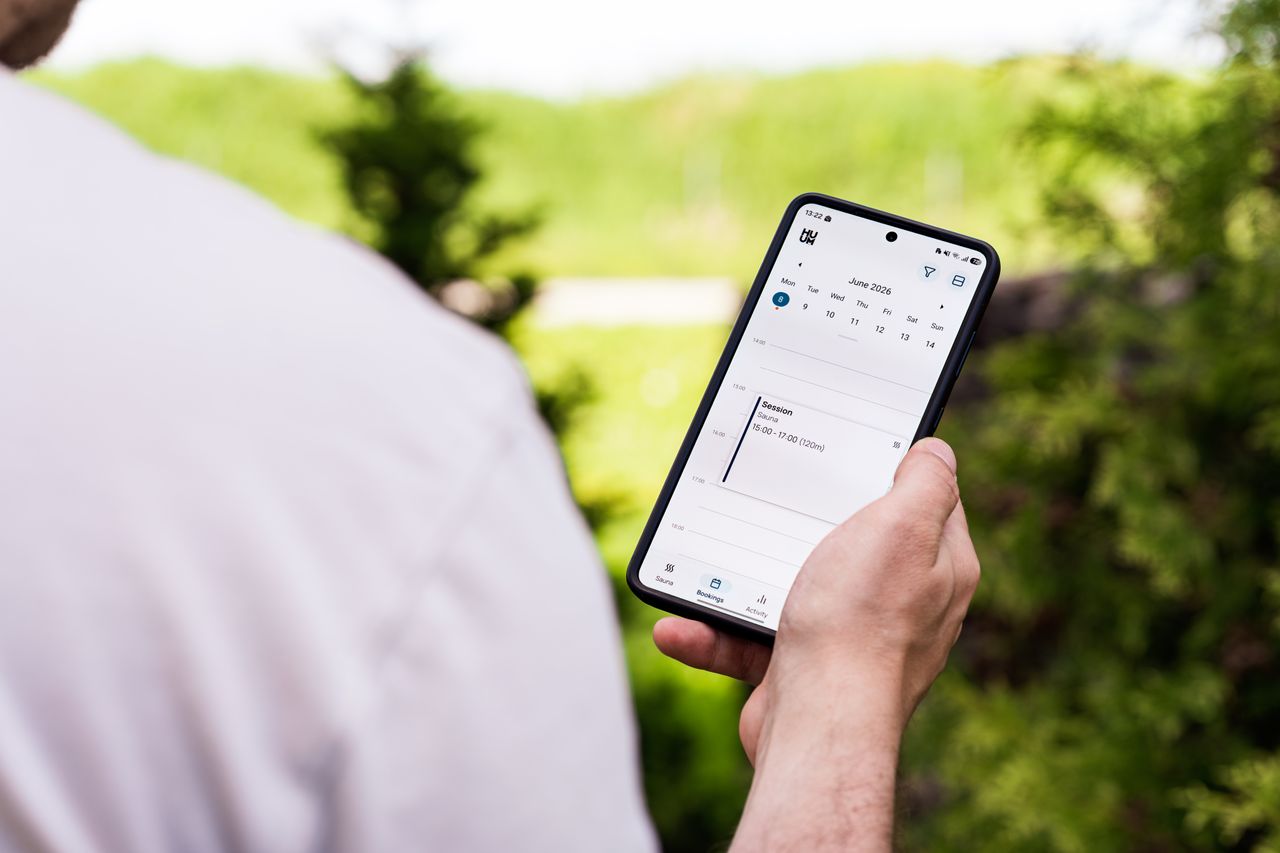 Someone outdoors checks a phone in their hand