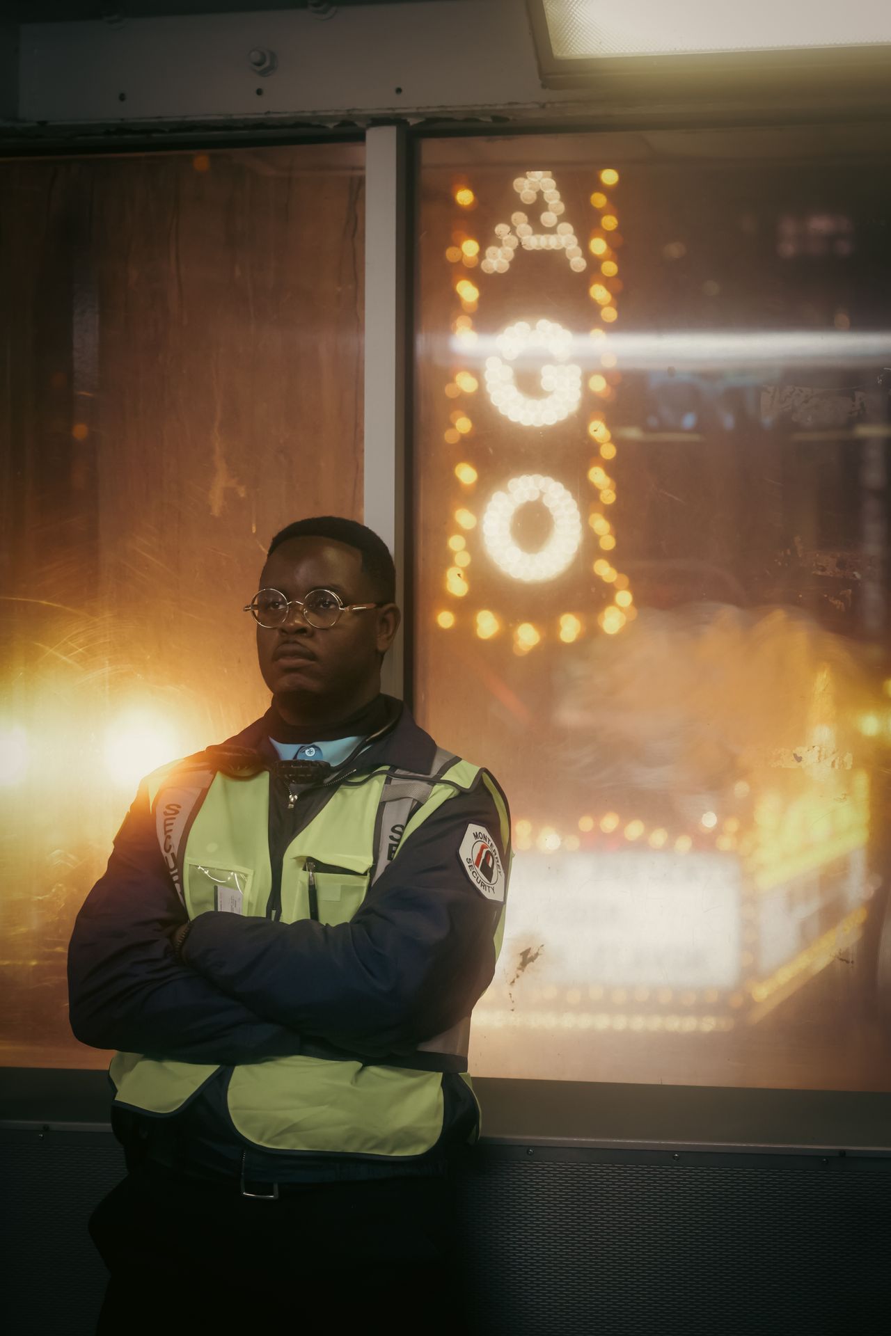A security guard in a high-visibility vest on duty at night