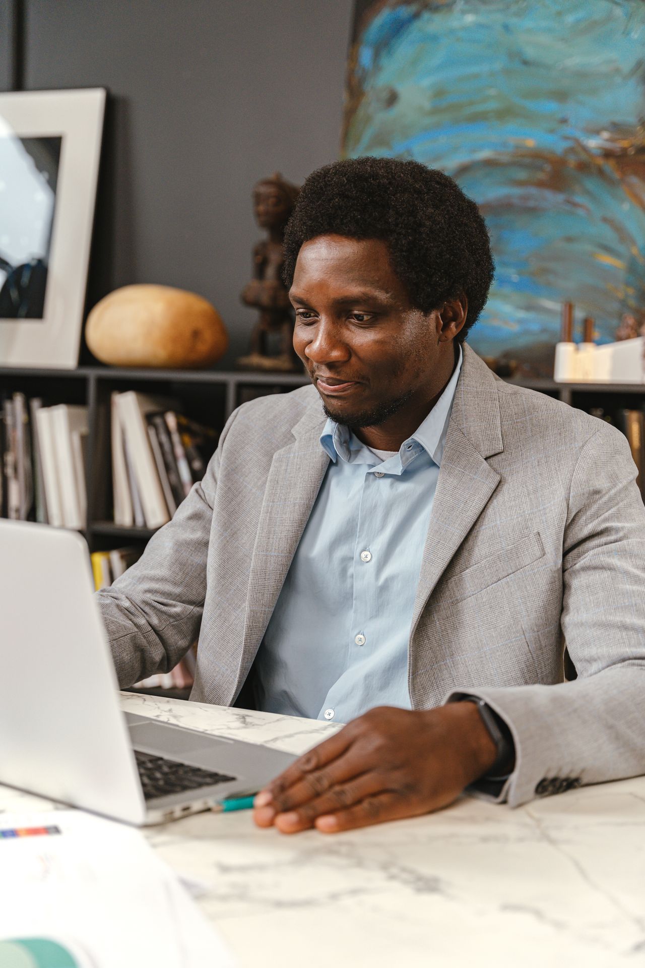 A manager smiles at his laptop at a desk
